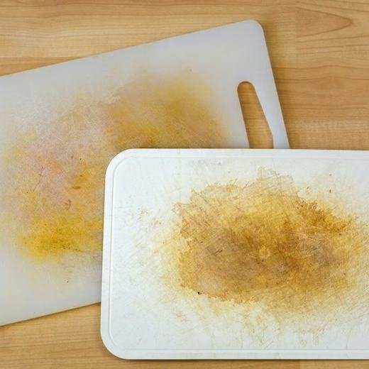 Stained plastic cutting board with deep knife cuts